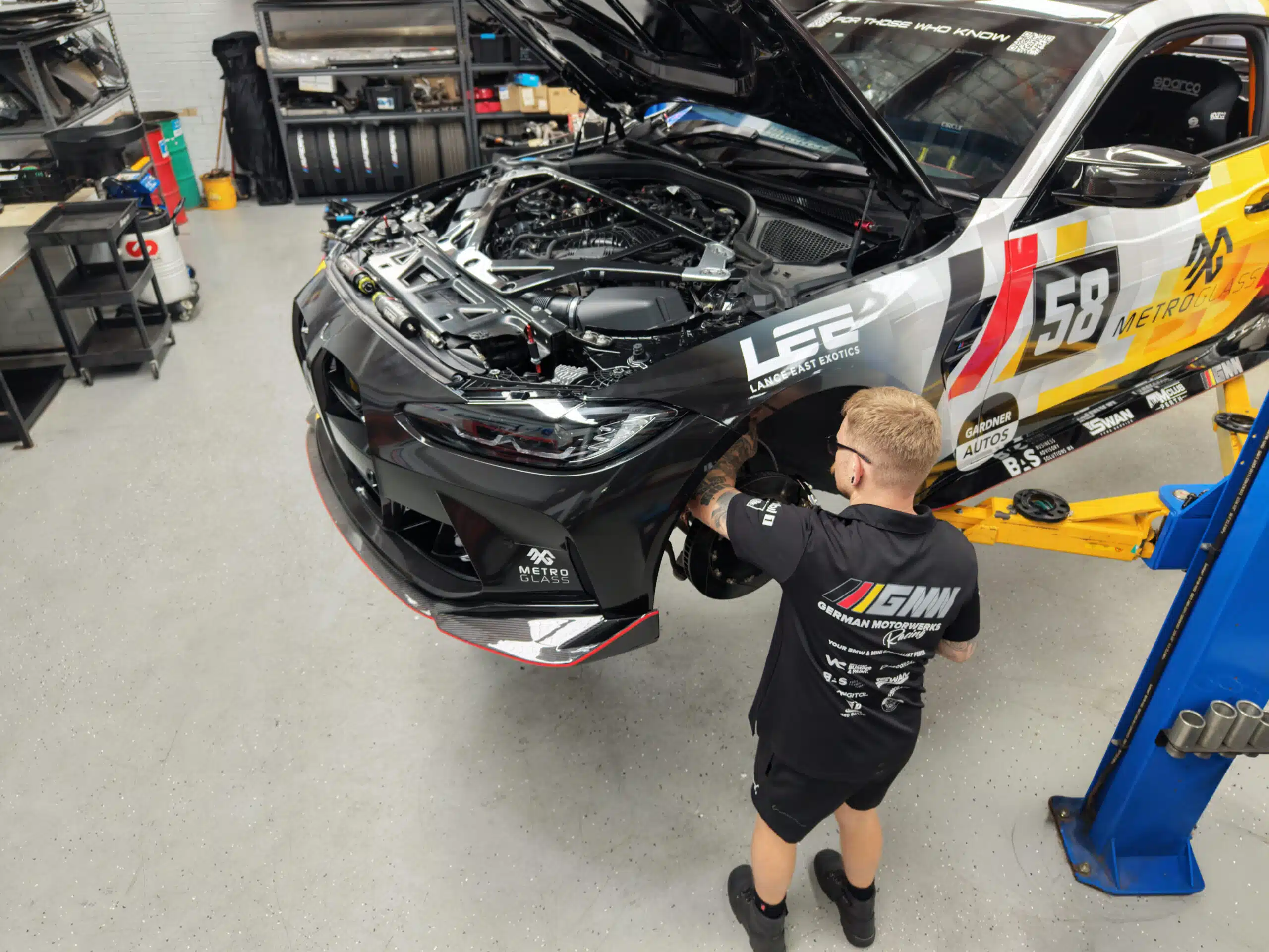 GMW technician is doing a suspension tuning on a lifting car