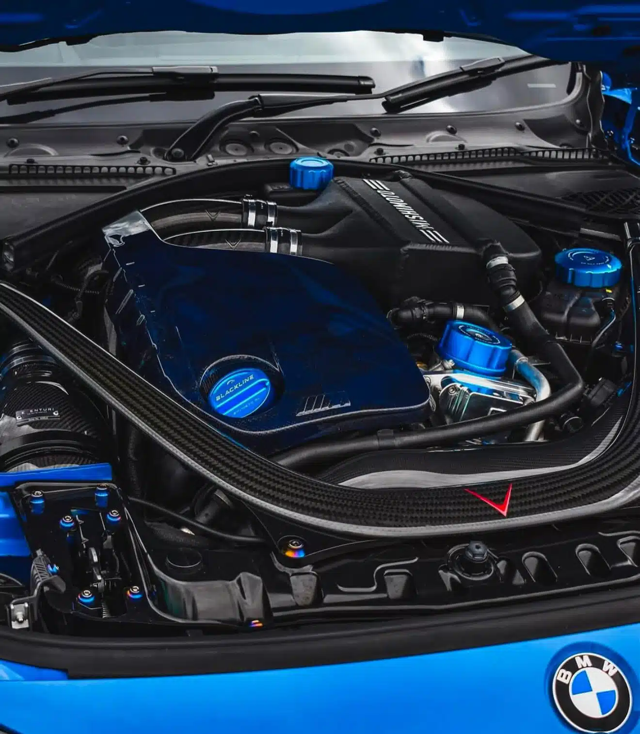 A blue BMW car with black engine and piping